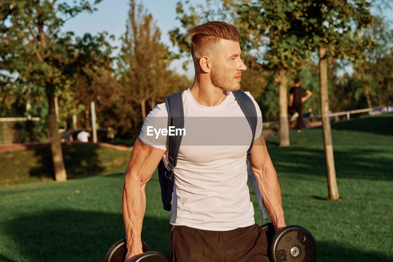 portrait of young man exercising in park