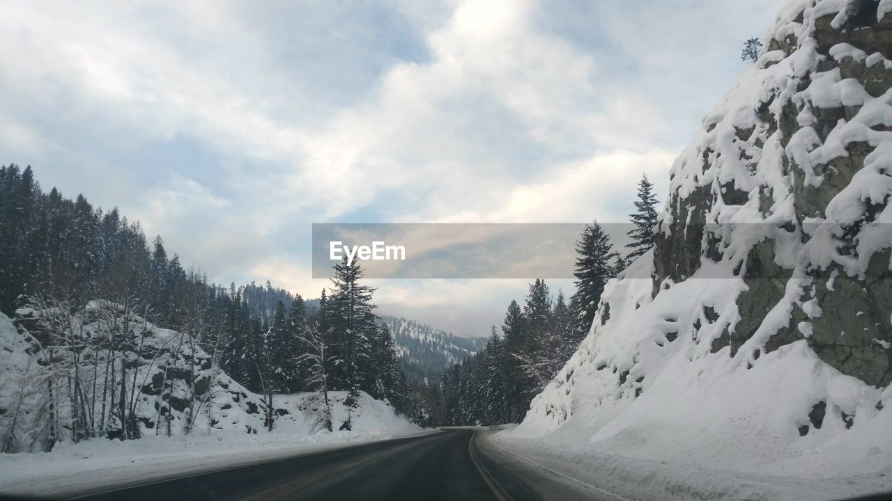 ROAD AMIDST TREES AGAINST SKY