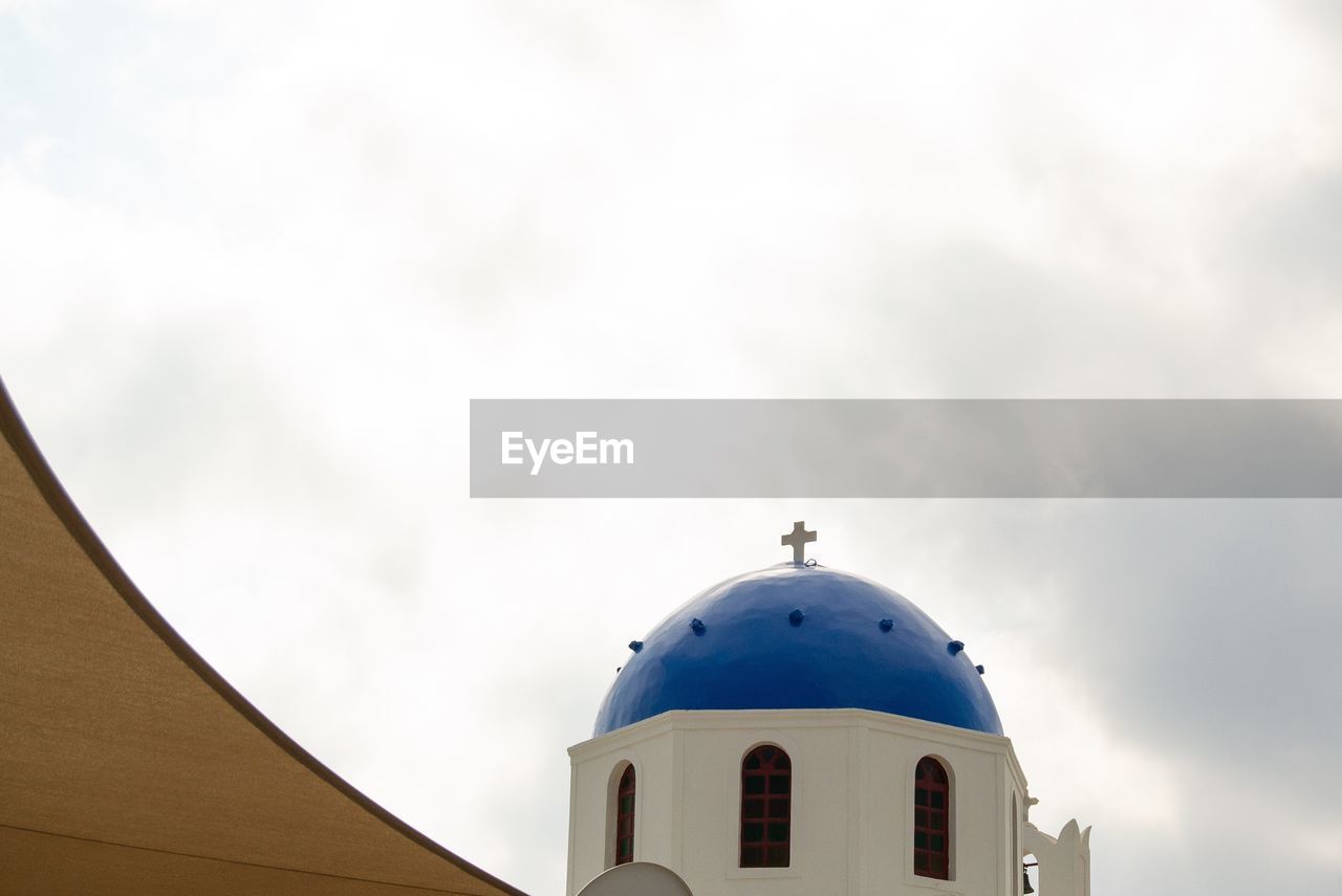 LOW ANGLE VIEW OF CHURCH AMIDST BUILDING AGAINST SKY