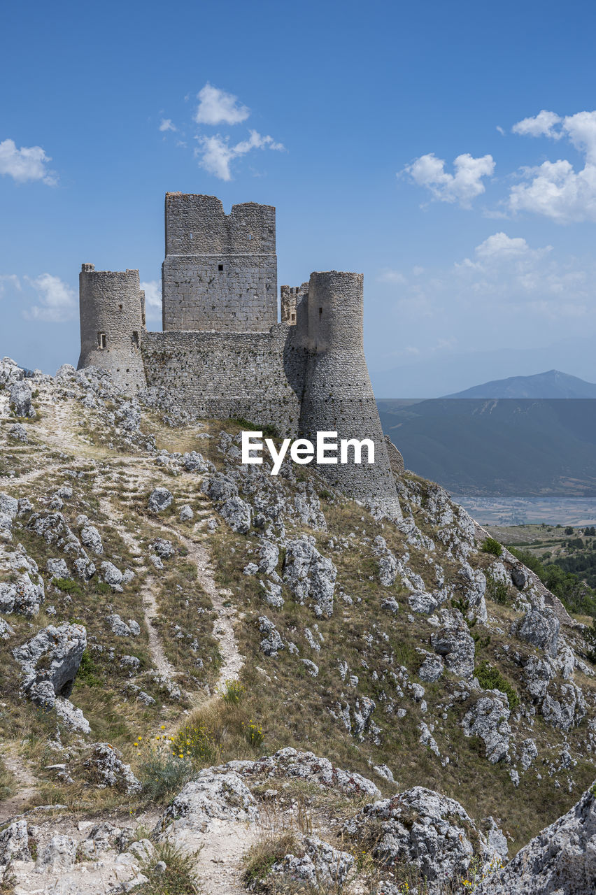 The ancient castle of rocca calascio with the beautiful mountains of abruzzo in the background
