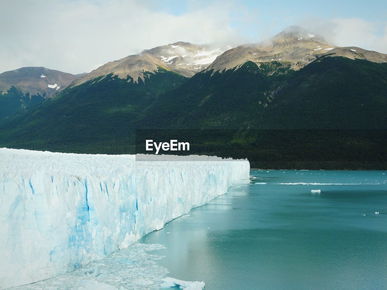 Glaciers in sea against mountain range