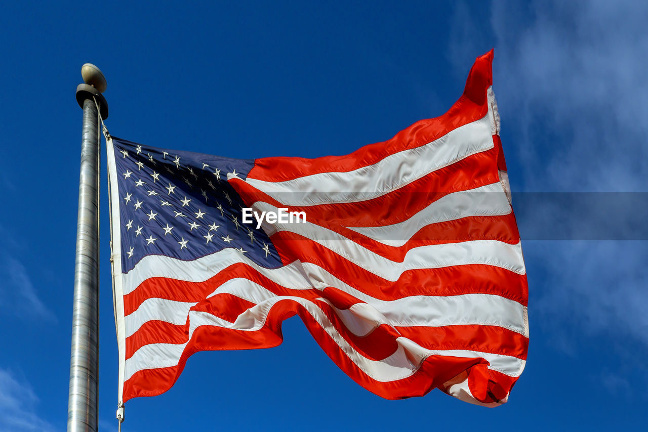 low angle view of american flag against blue sky
