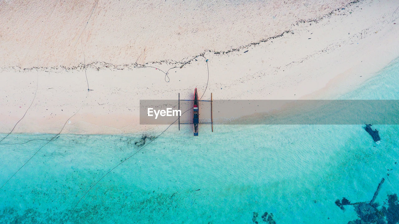 High angle view of outrigger moored on shore at beach