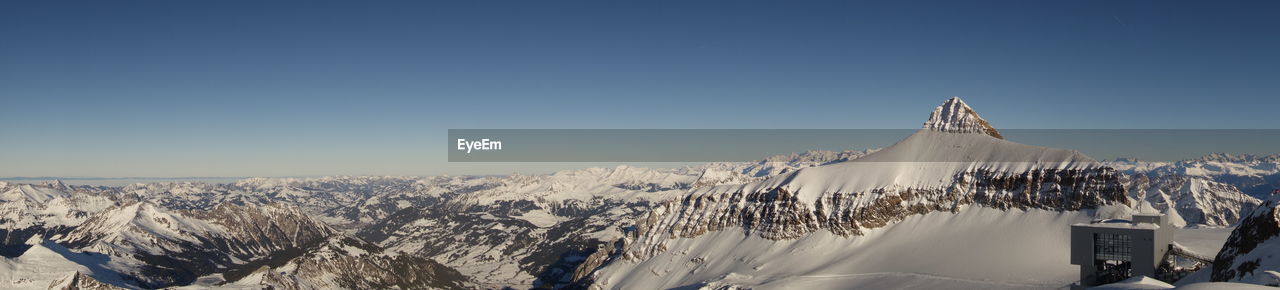 Scenic view of snow covered mountains against clear sky