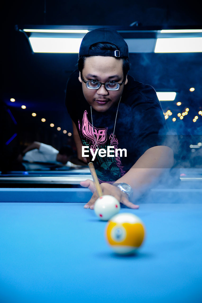 portrait of young woman playing pool