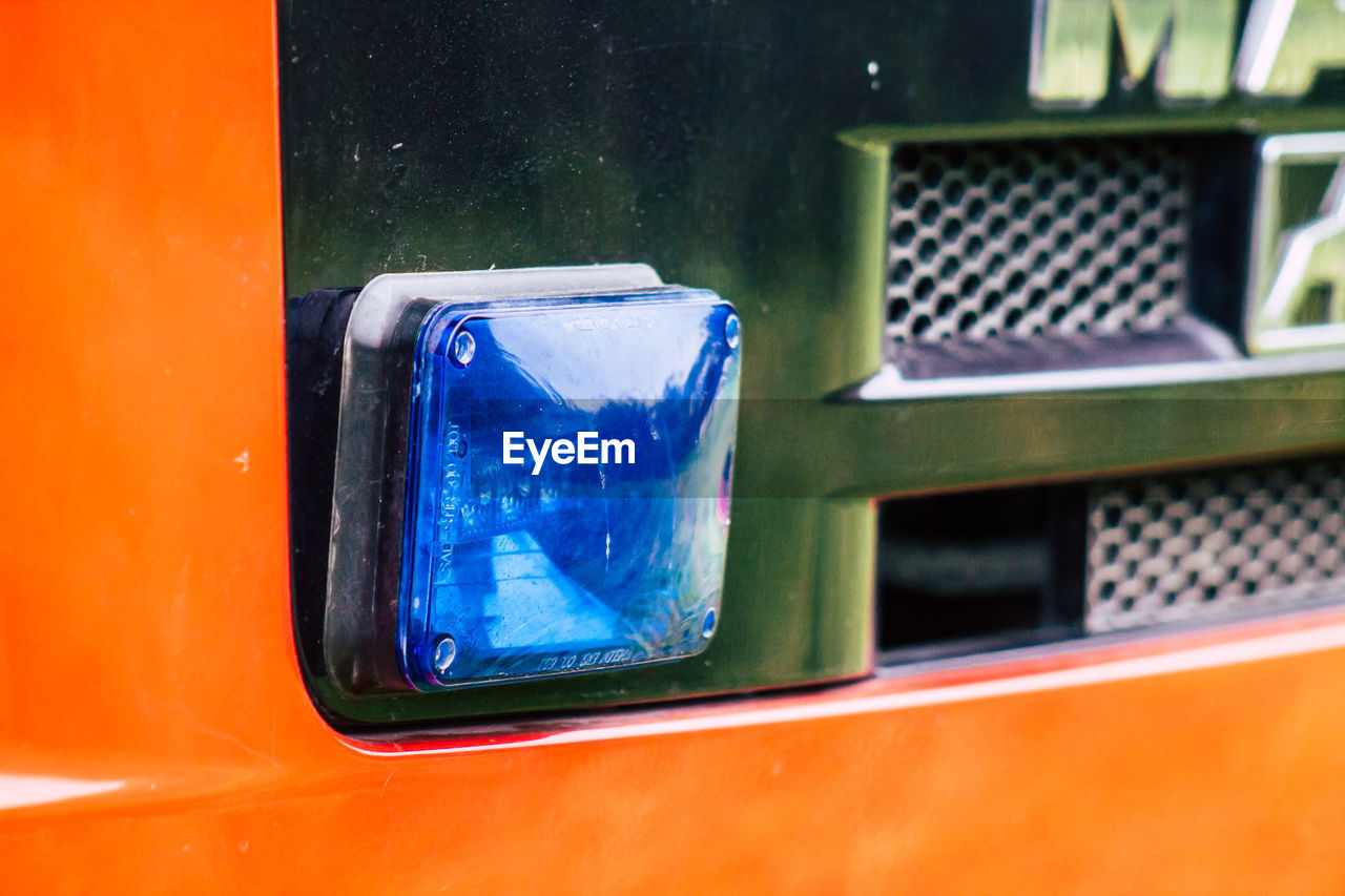 CLOSE-UP OF CAR WINDOW WITH REFLECTION OF ORANGE MIRROR