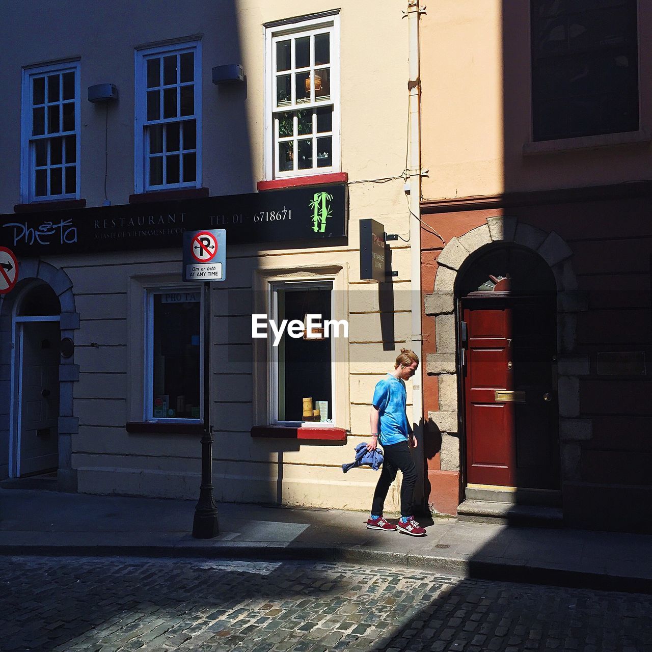 WOMAN WALKING ON CITY STREET