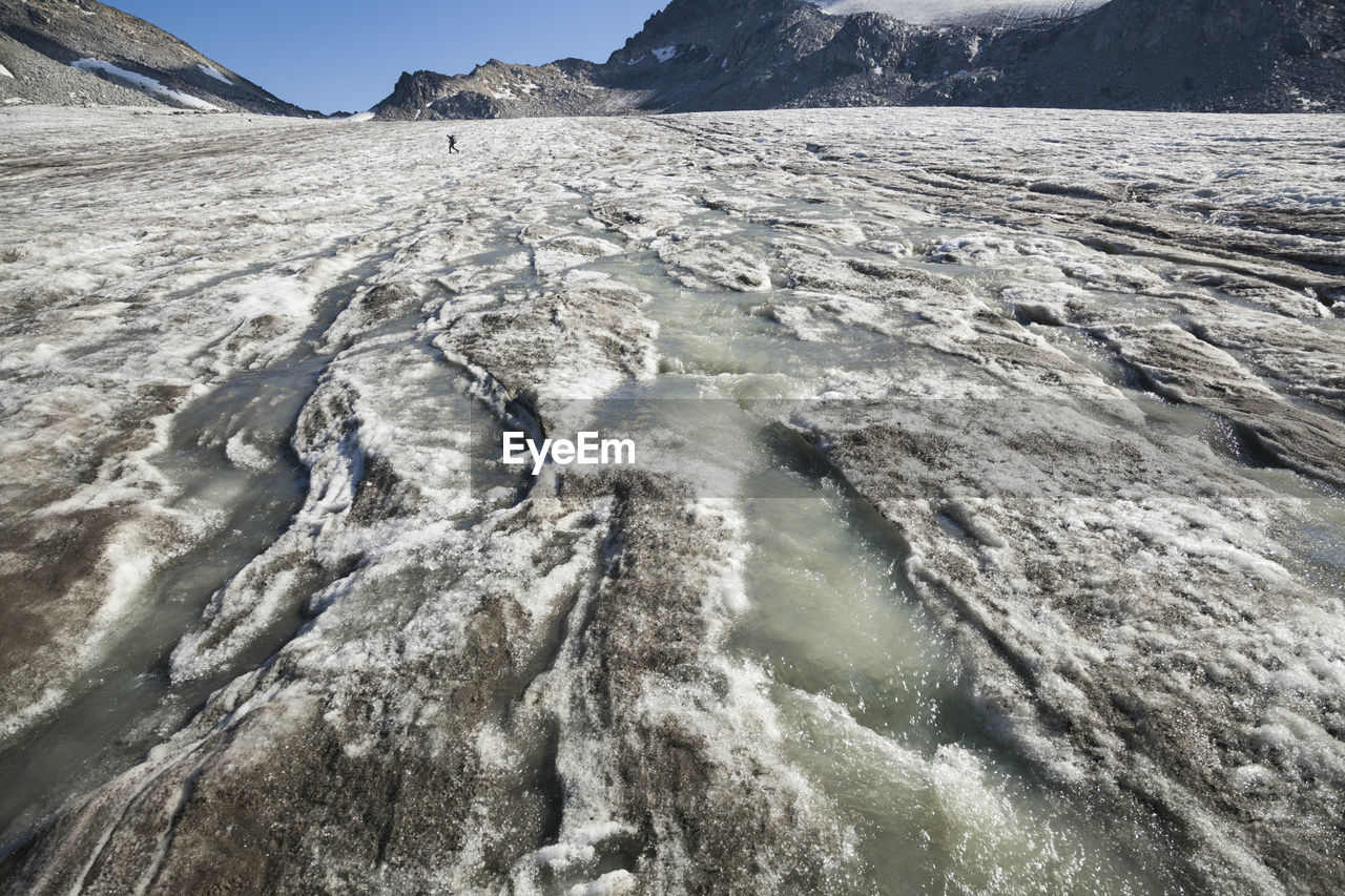 Man hikes on melting snowbird glacier, talkeetna mountains, alaska