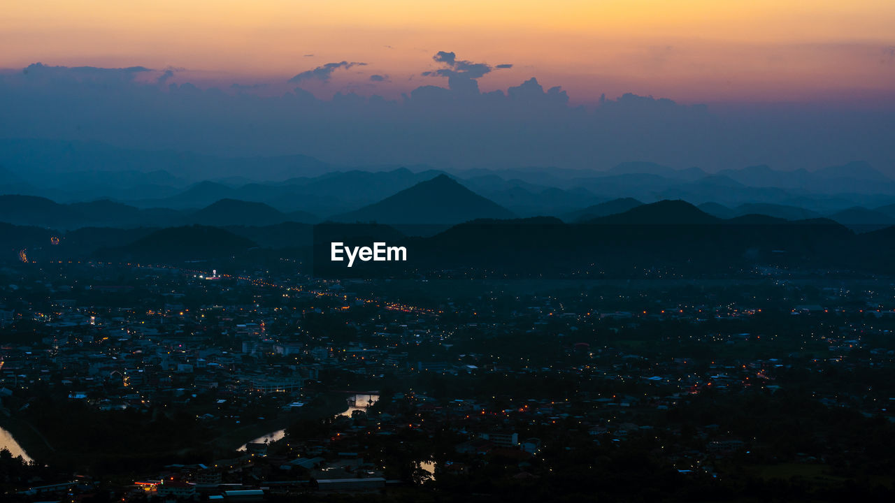 High angle shot of illuminated cityscape against sky at sunset