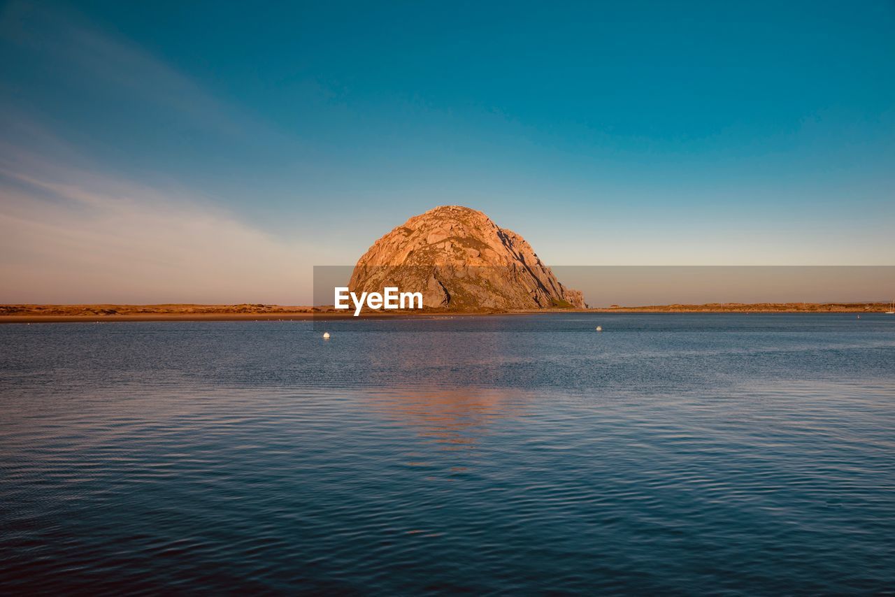 ROCK FORMATION IN SEA AGAINST SKY