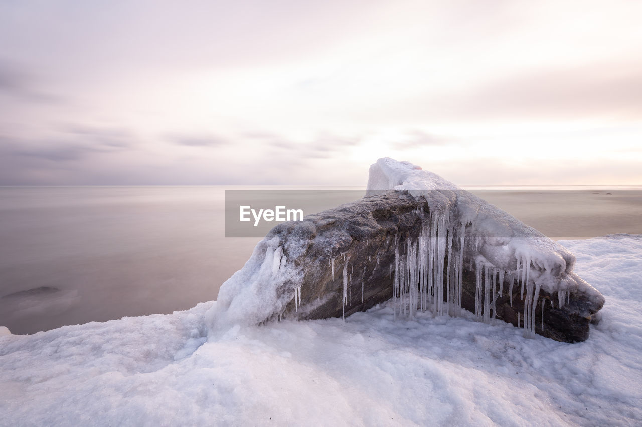 Dilapidated structure covered in ice on the lakeshore