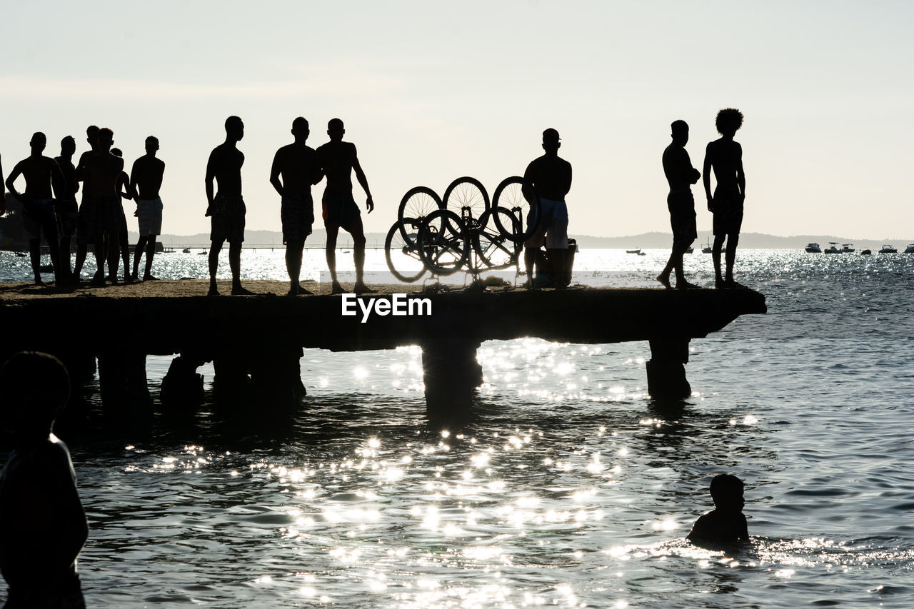 Young people, in silhouette, are seen having fun on the crush bridge in the late afternoon 