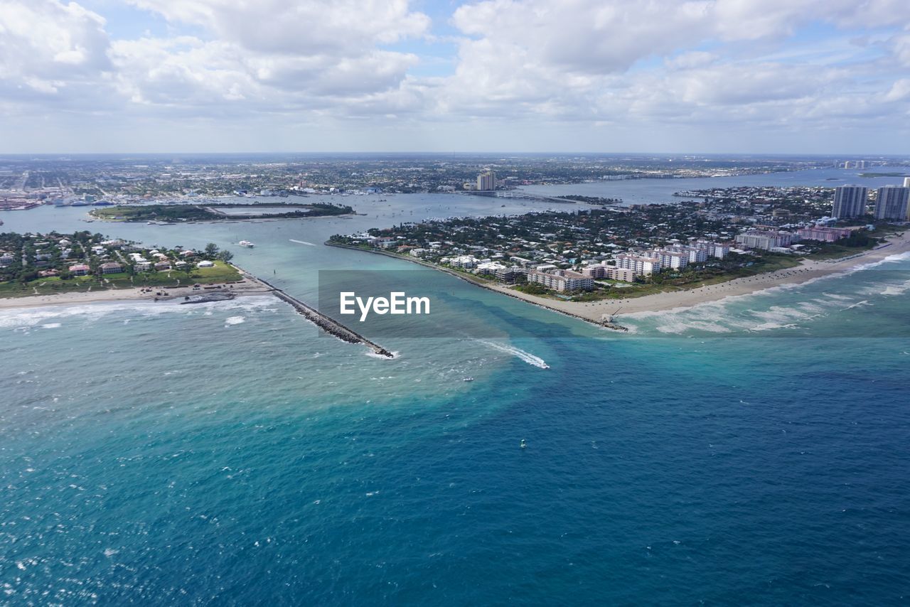 Aerial view of city by lake worth inlet against sky