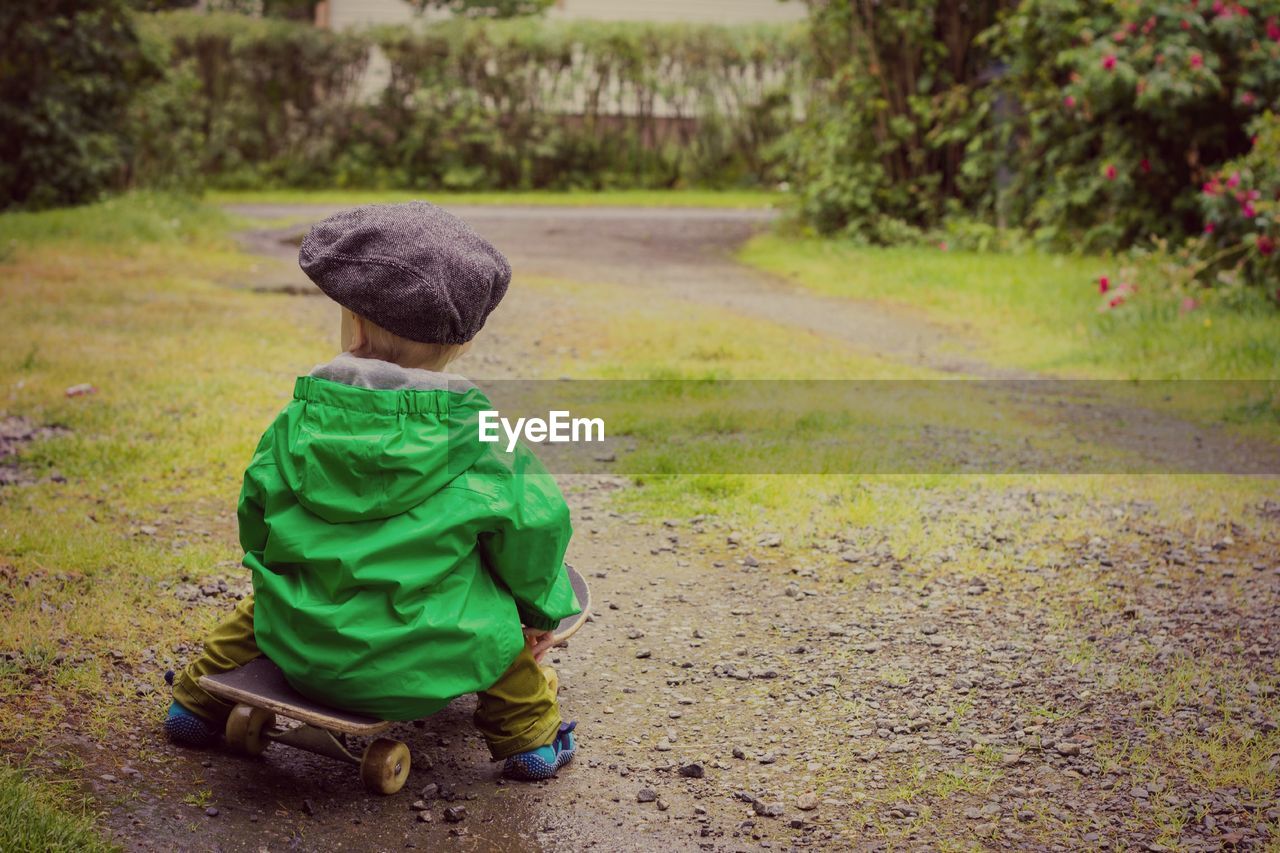 Boy sitting on skateboard 