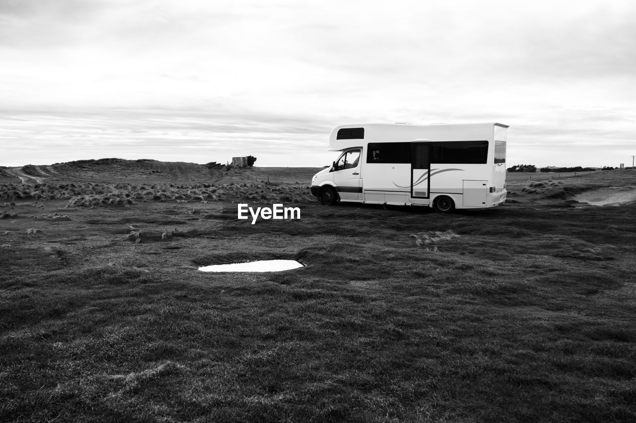 Camping van on landscape against sky