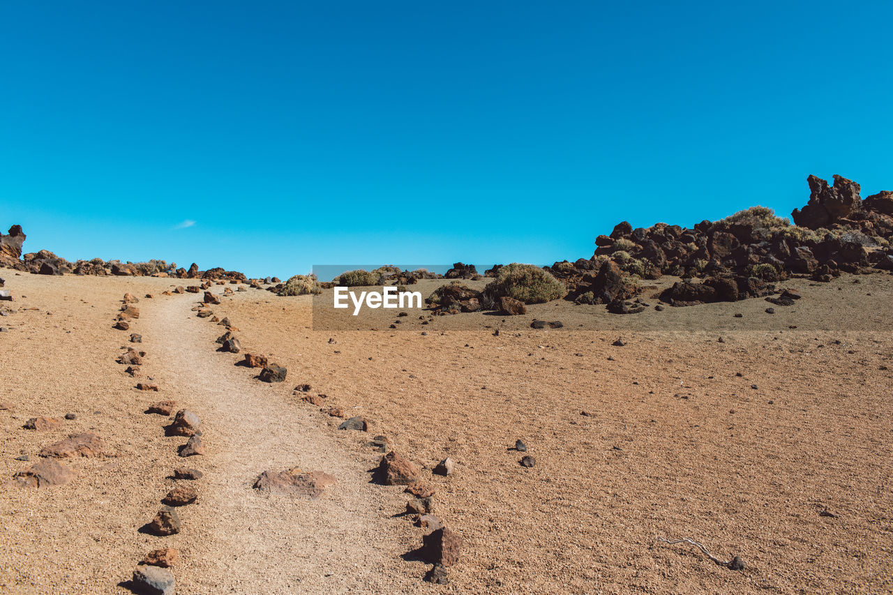 Panoramic view of desert against clear blue sky