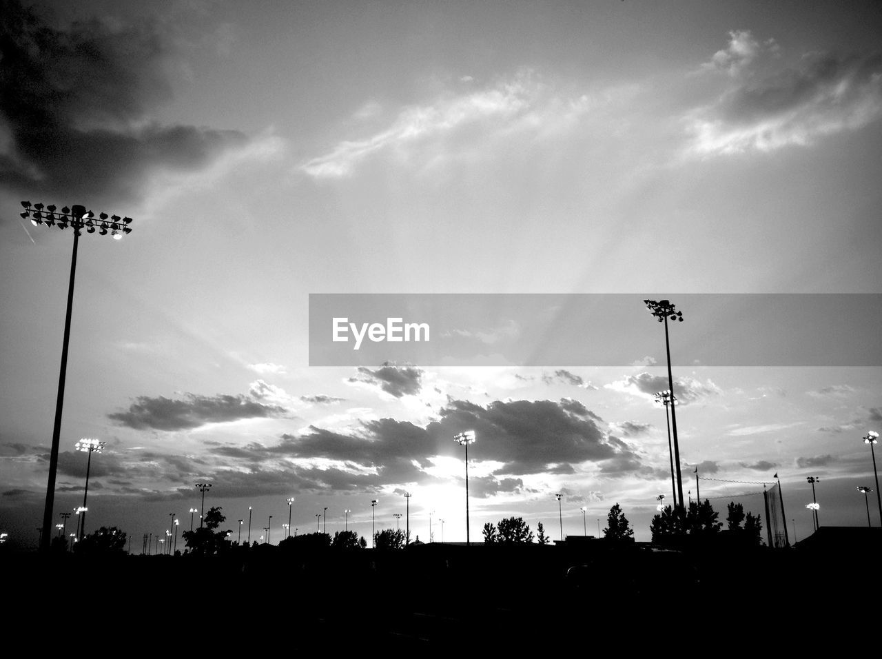Low angle view of illuminated floodlights against sky
