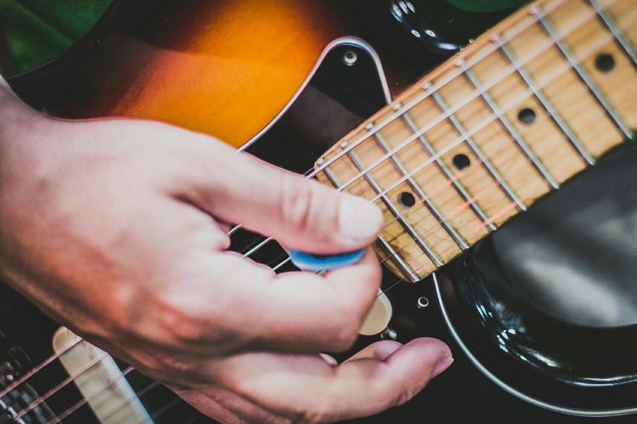 CLOSE-UP OF HANDS PLAYING GUITAR