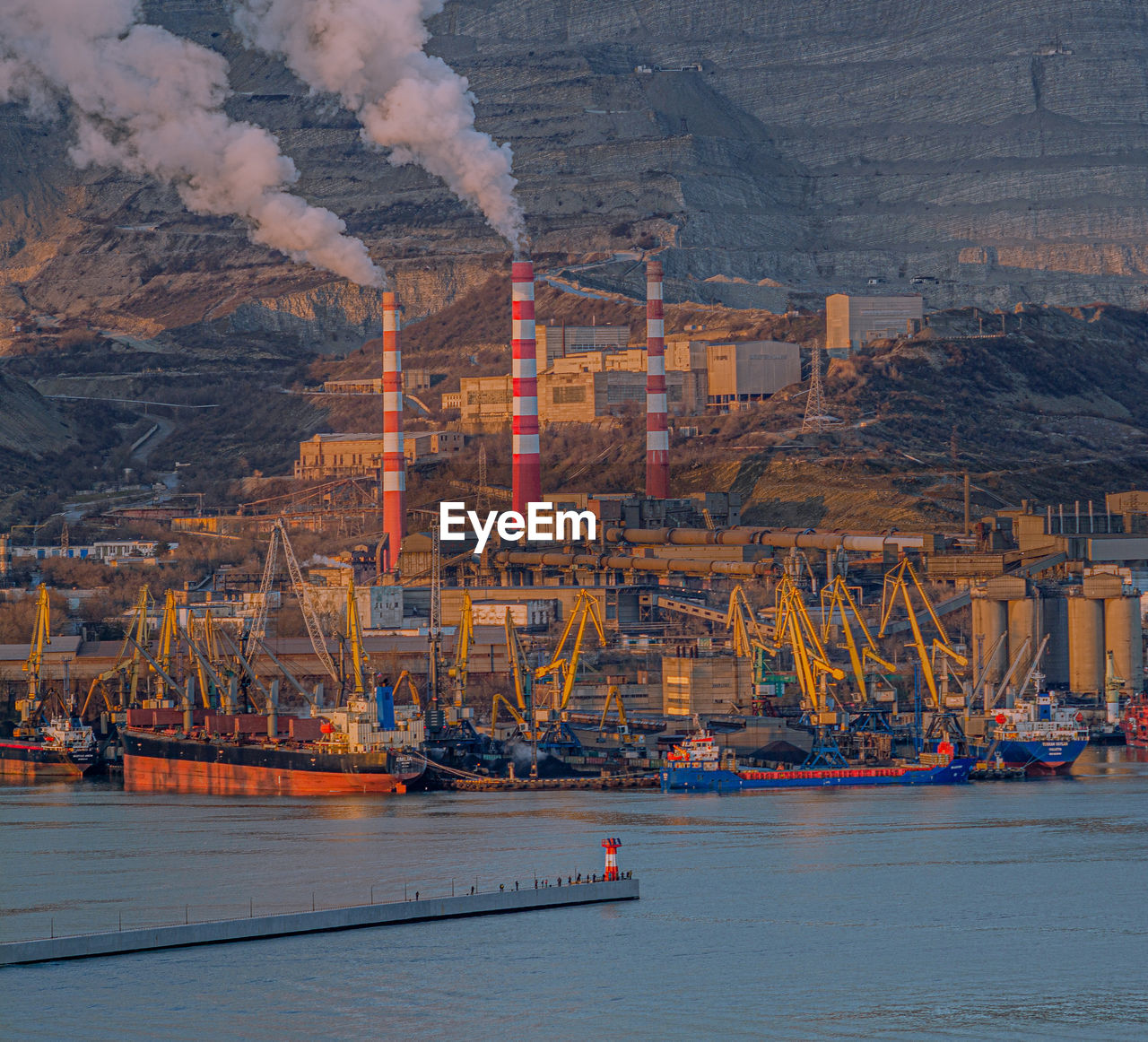 AERIAL VIEW OF FACTORY BY SEA AGAINST SKY