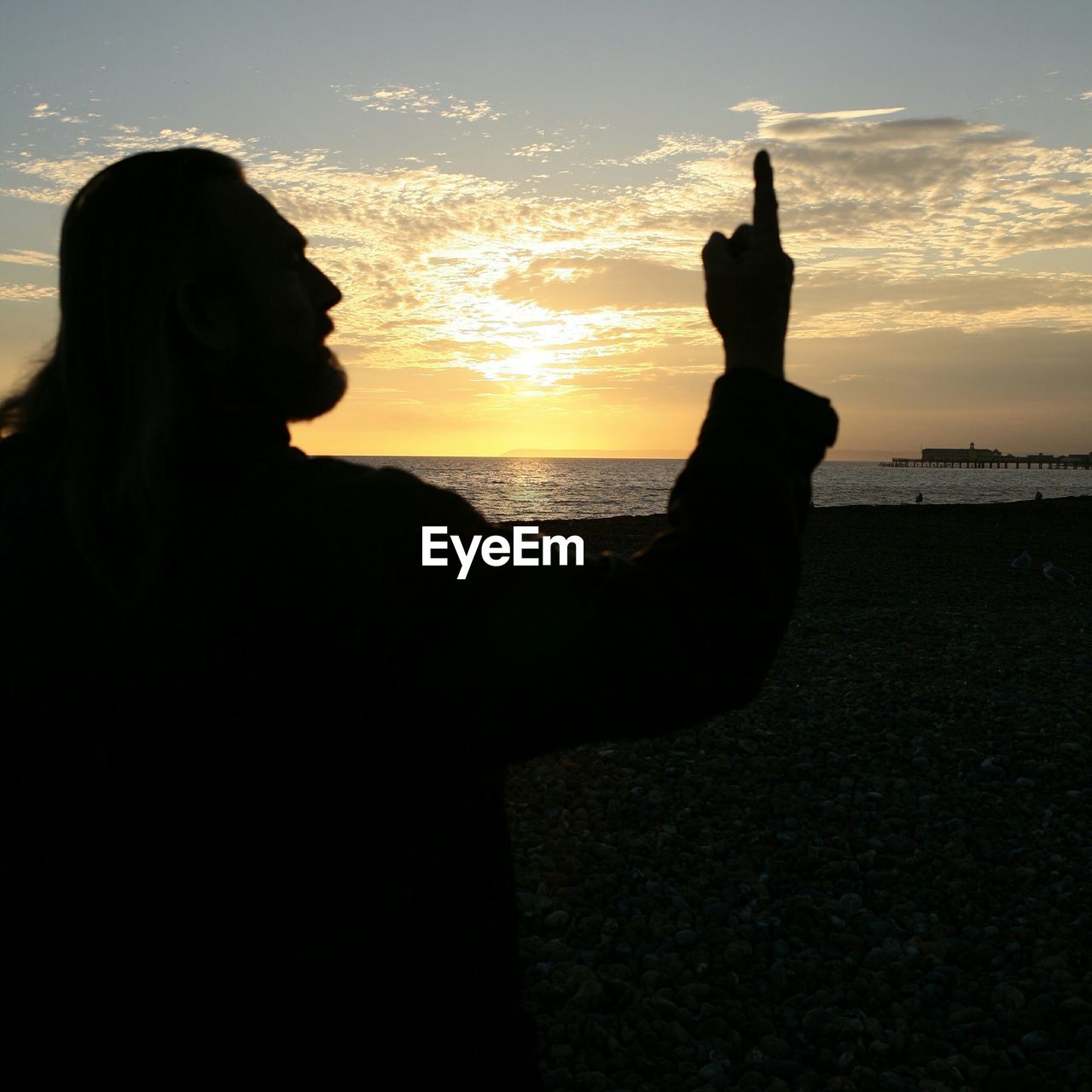 SILHOUETTE OF PEOPLE ON BEACH AT SUNSET