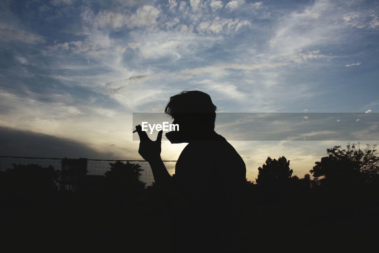 Silhouette man standing against sky during sunset 