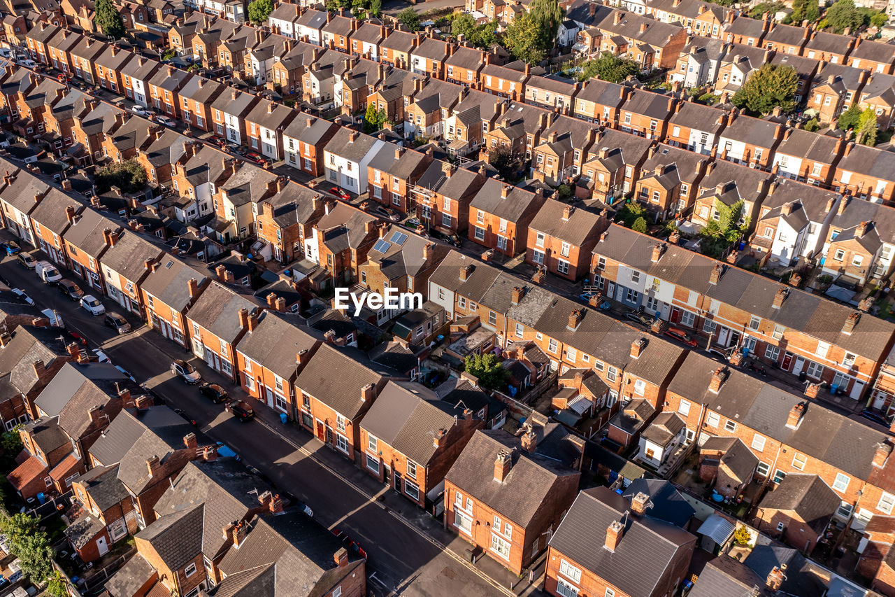 Aerial view above rooftops of back to back terraced houses on a residential estate in north england