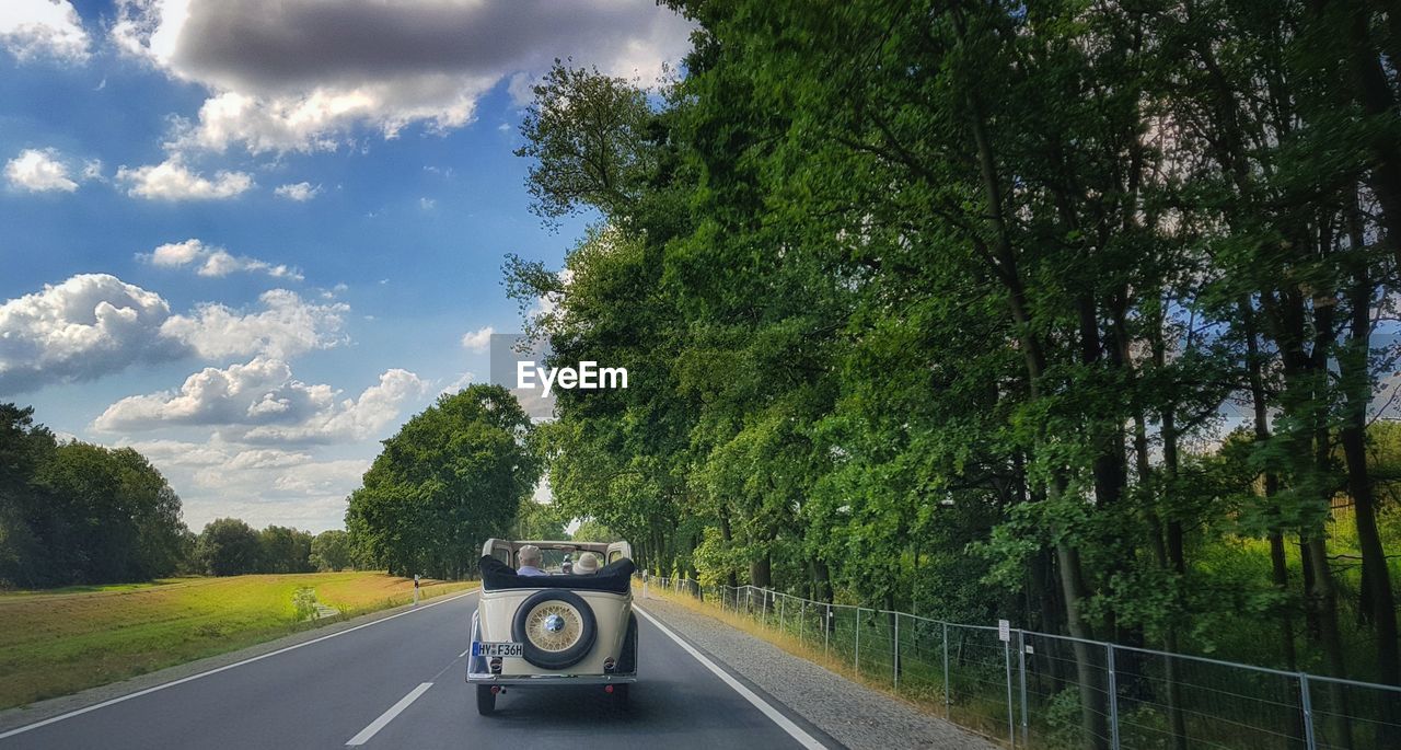 CAR ON ROAD AGAINST SKY