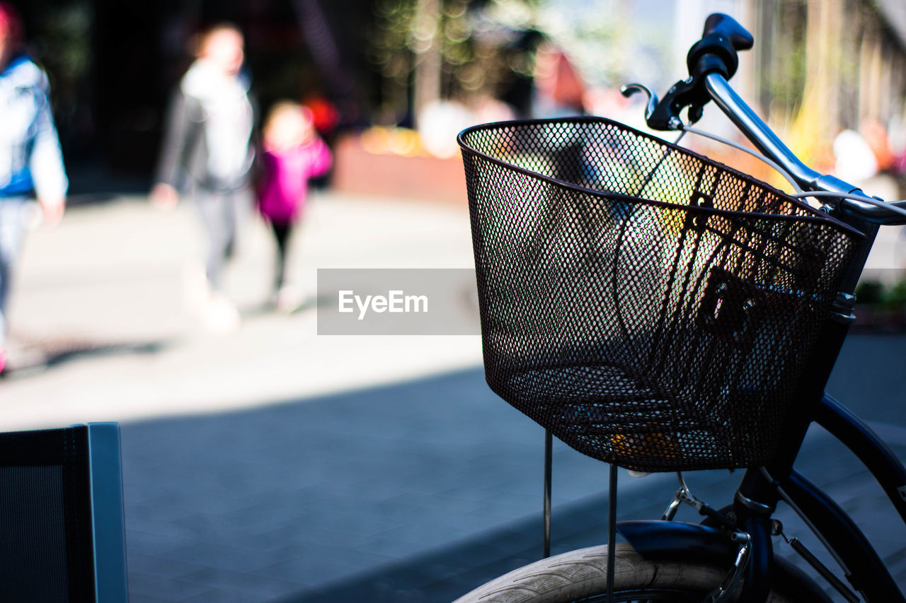 CLOSE-UP OF BICYCLE IN BASKET ON STREET