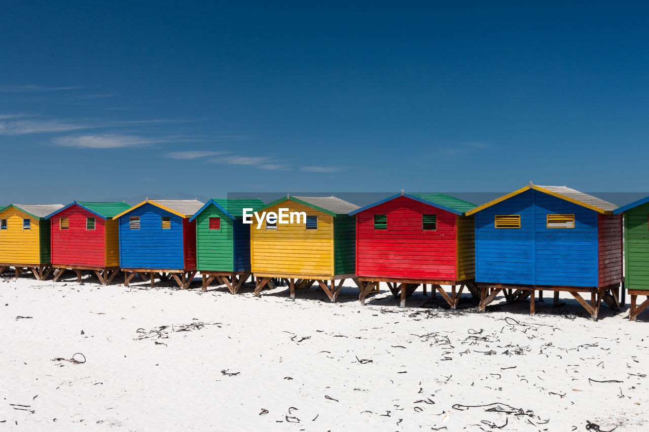 Multi colored beach houses in muizenberg near cape town, south africa against blue sky