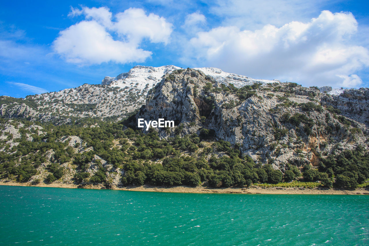 Scenic view of sea and mountains against sky