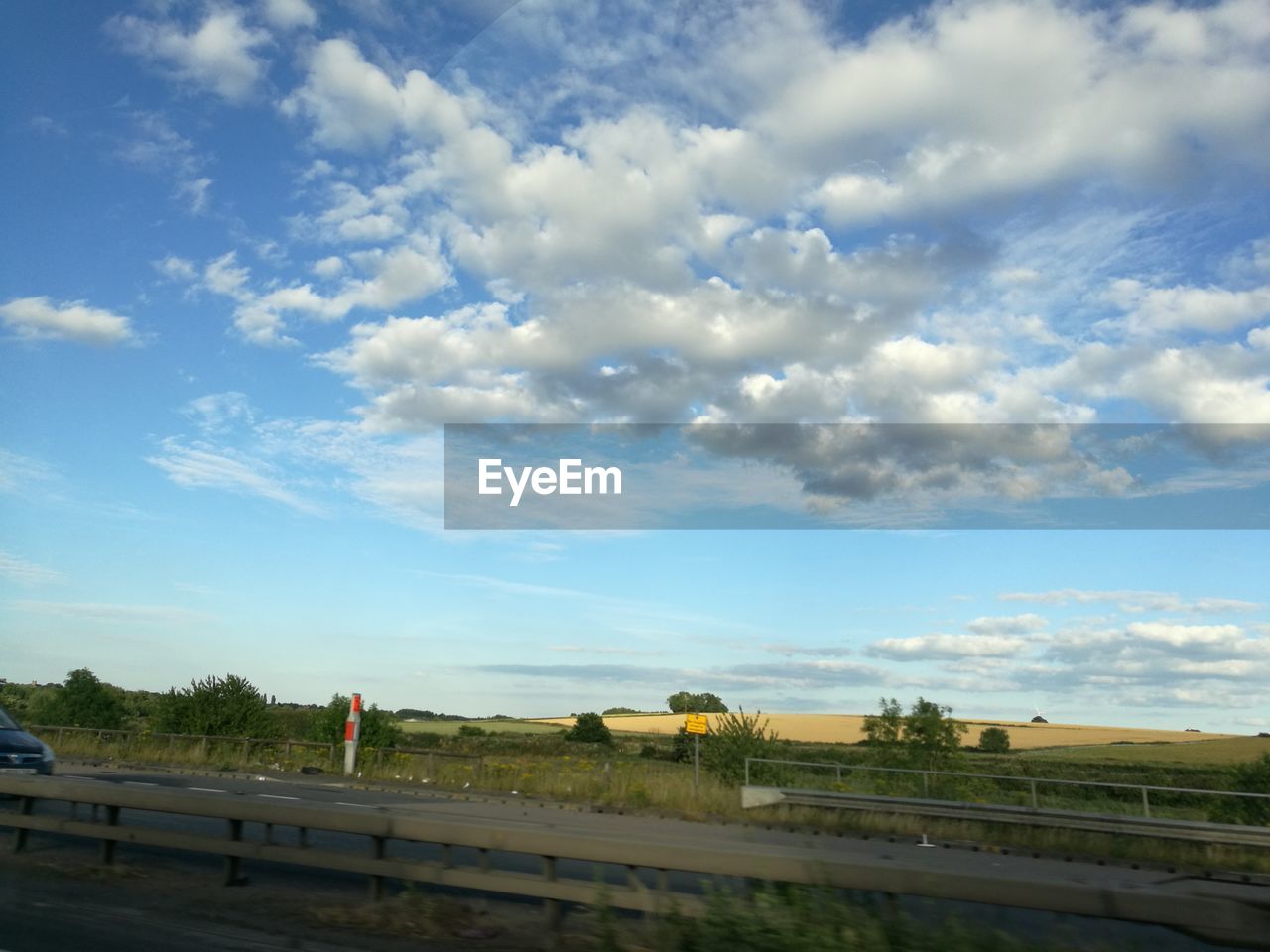 SCENIC VIEW OF SKY AND TREES AGAINST BLUE CLOUDY DAY