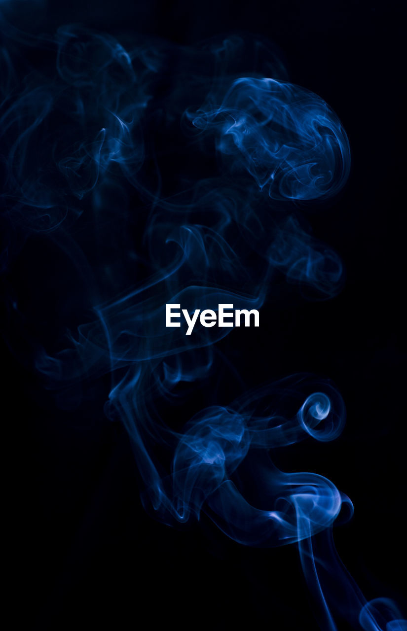 Close-up of blue smoke against black background