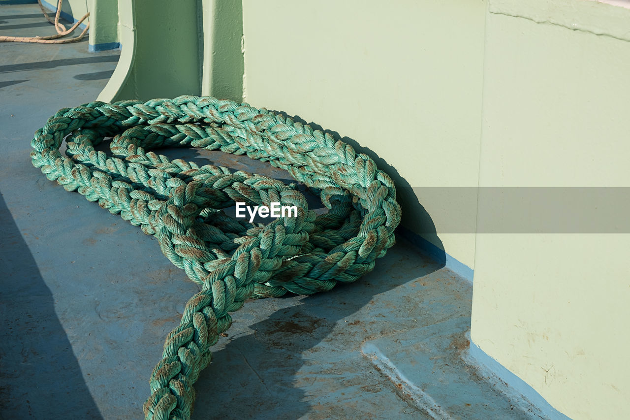 CLOSE-UP OF ROPE TIED TO WALL