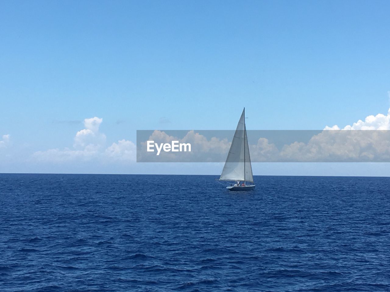 Sailboat sailing on sea against sky