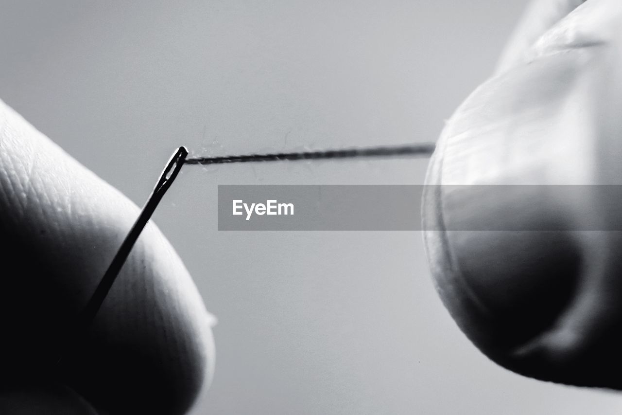 Close-up of hands holding needle and thread