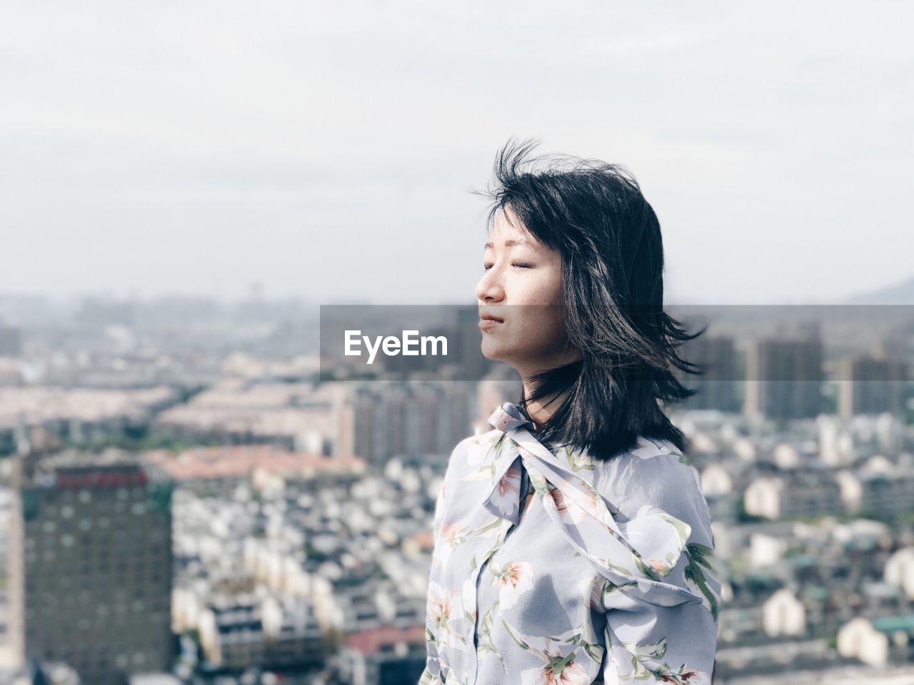 Young woman standing against cityscape in city