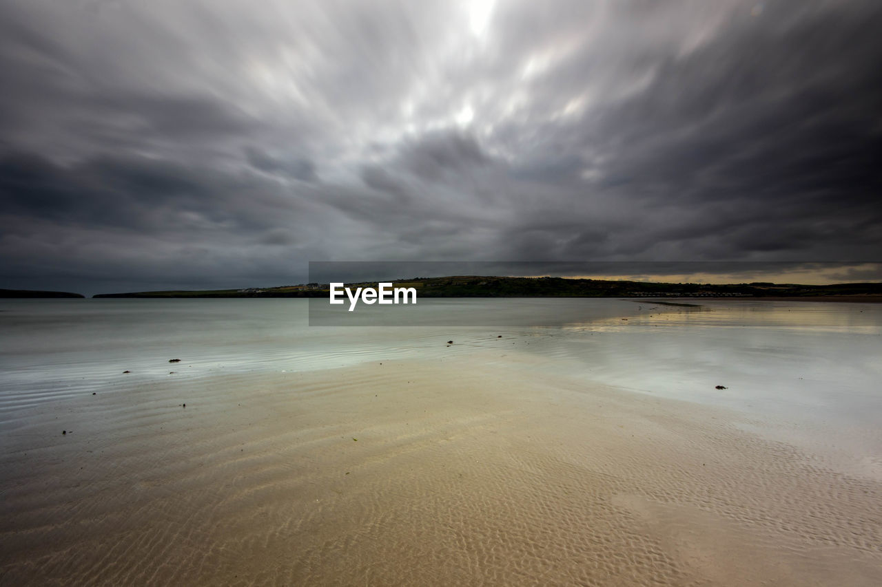 SCENIC VIEW OF BEACH AGAINST CLOUDY SKY