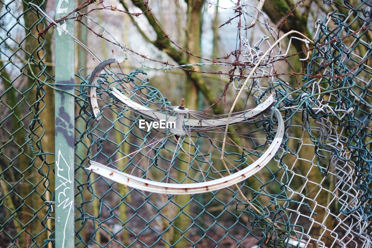 CLOSE-UP OF CHAINLINK FENCE AGAINST SKY