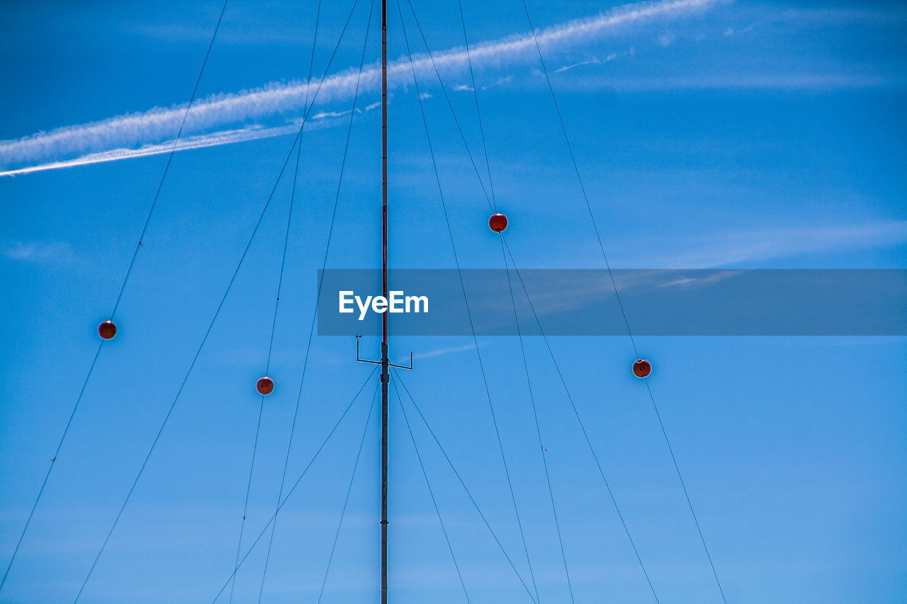 Low angle view of communication tower against blue sky