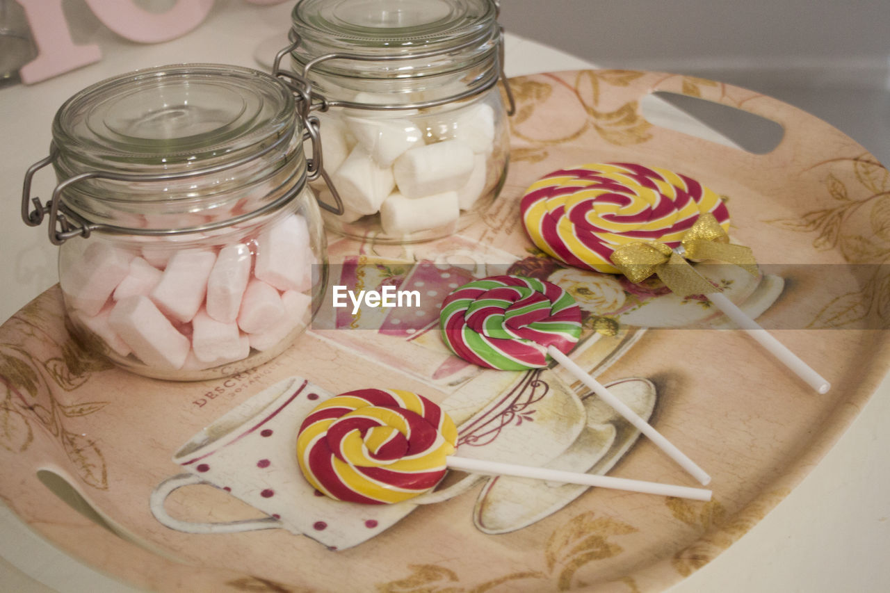 Lollipops and jars of marshmallow on tray