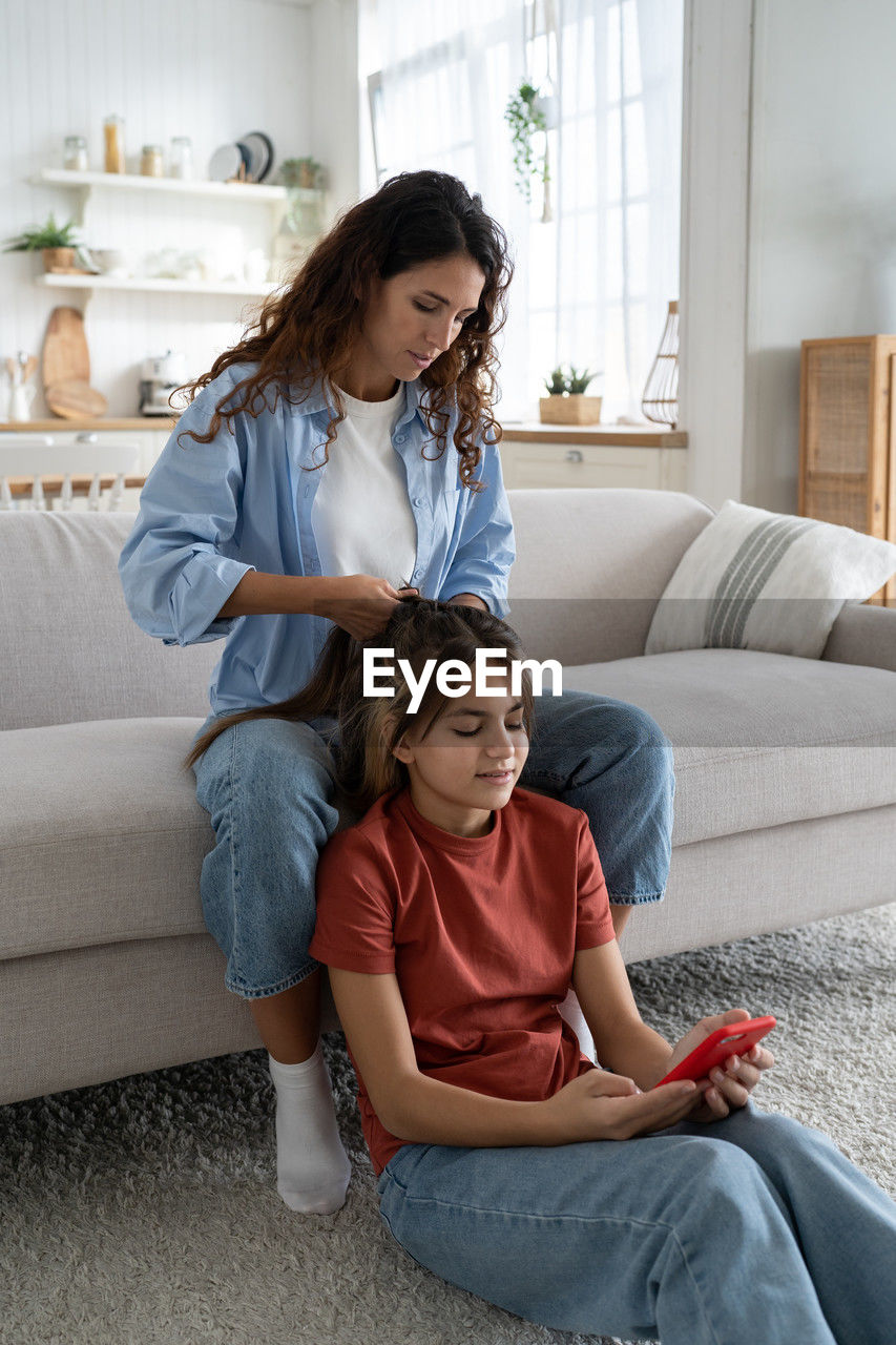 mother and daughter sitting on bed at home