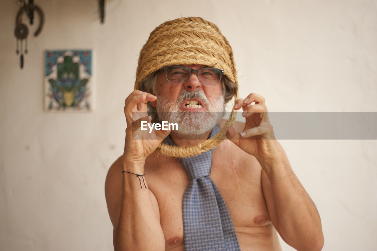 PORTRAIT OF MAN WEARING HAT HOLDING CAMERA