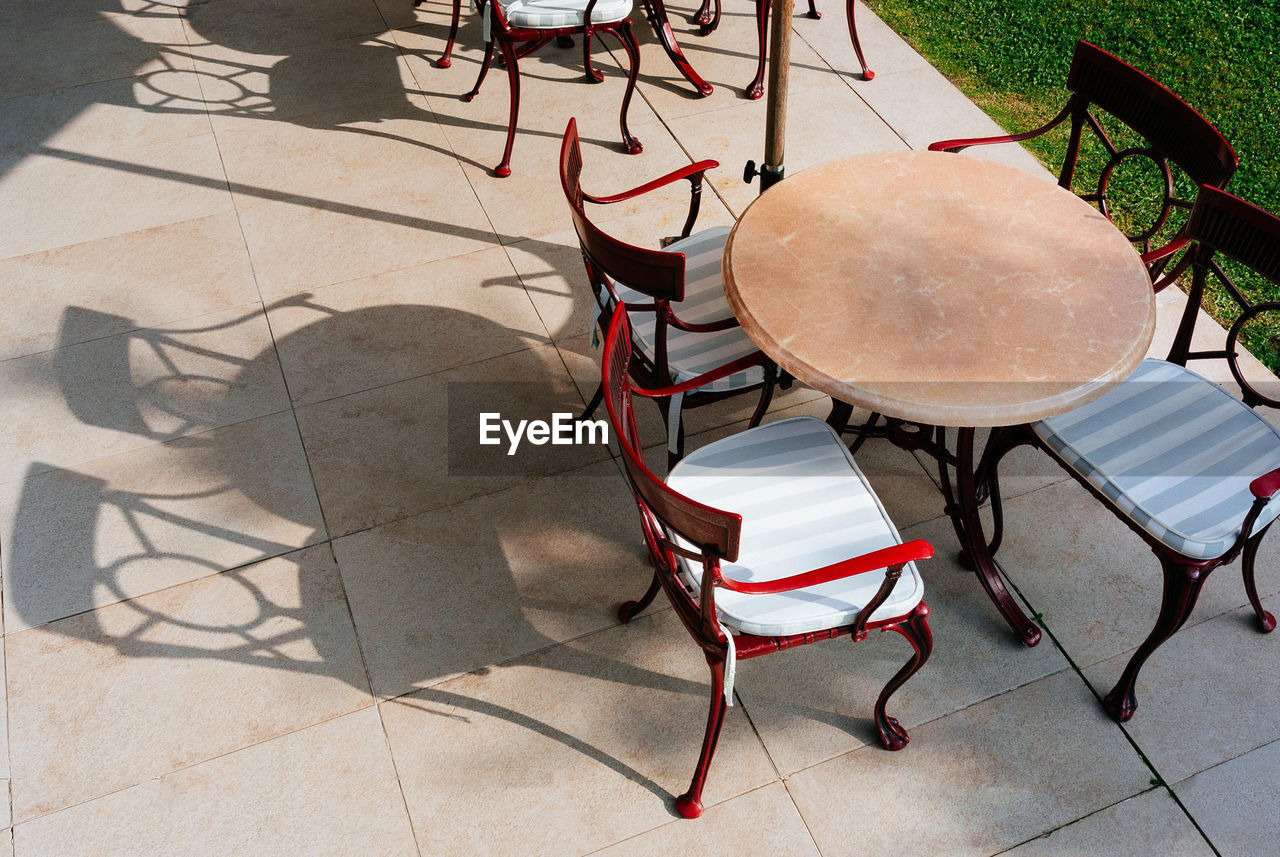 High angle view of empty chairs amidst table at outdoor restaurant