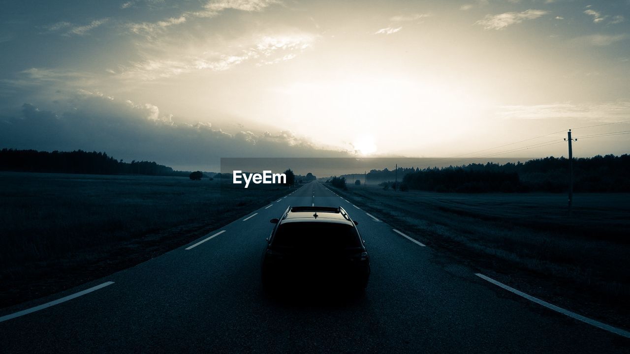 Car on road against sky during sunset