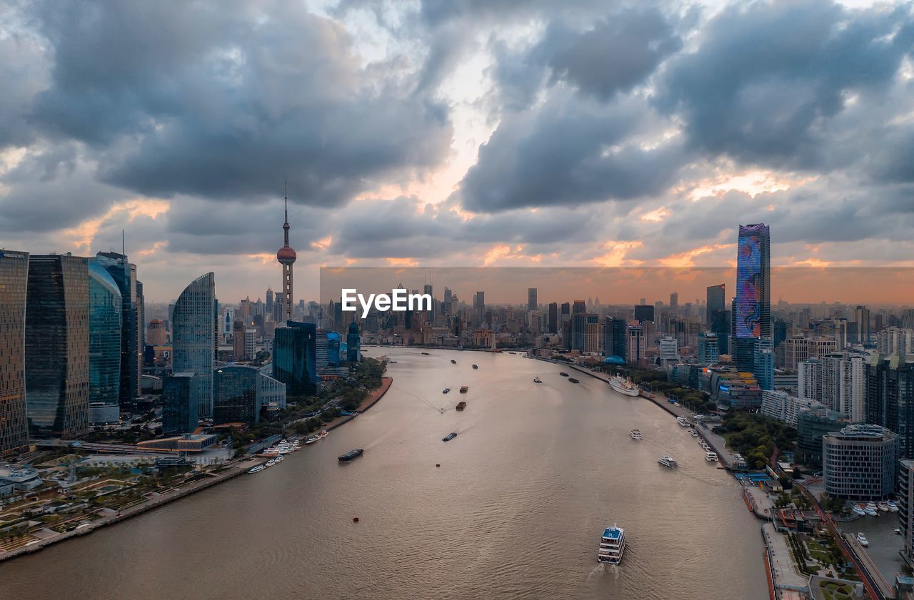 Panoramic view of buildings in city against cloudy sky