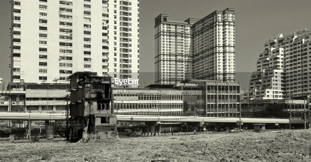 TRAIN ON RAILROAD TRACK BY BUILDINGS IN CITY