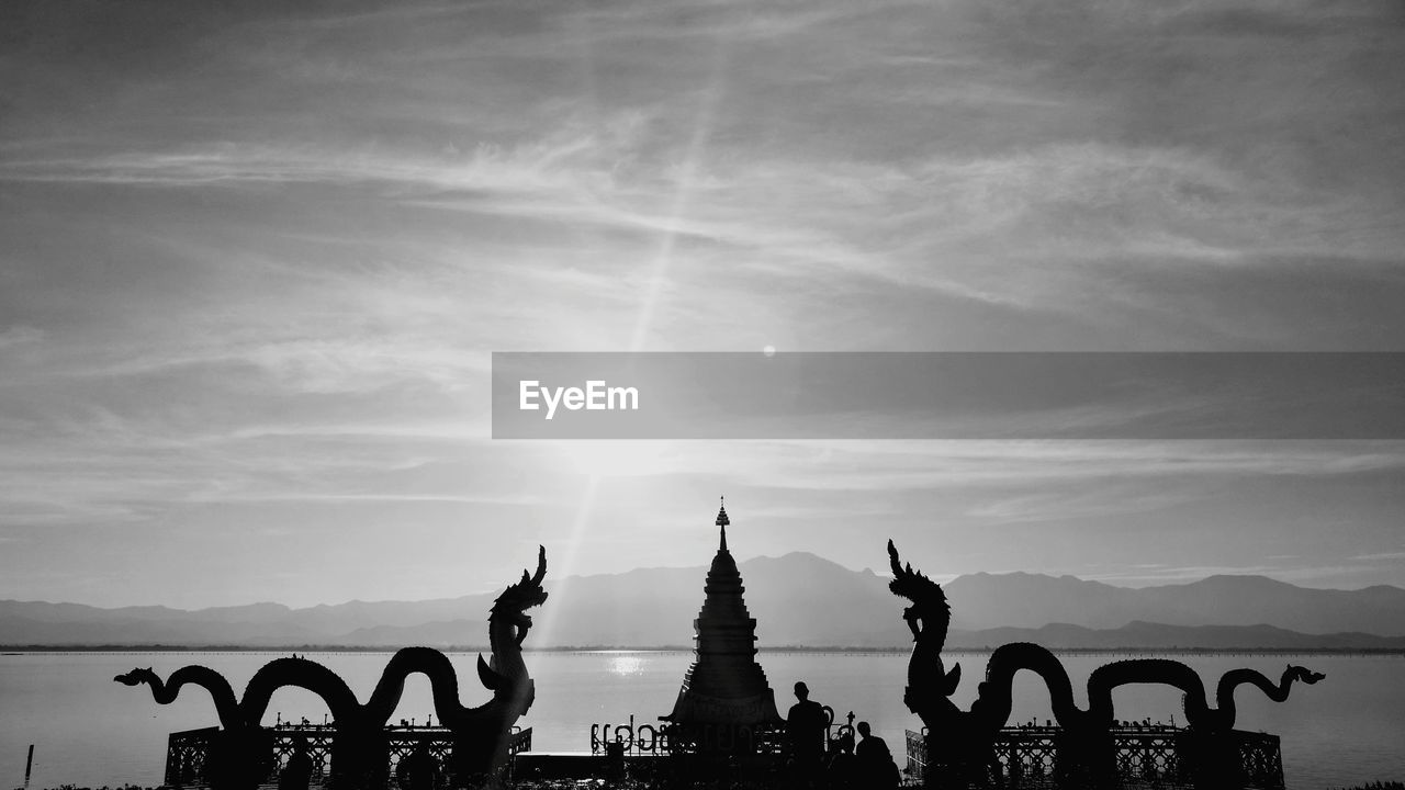 Silhouette of statue against cloudy sky