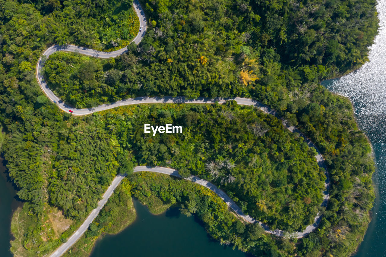 Aerial view road along mea suai dam connecting the city and green forest at chiang rai thailand