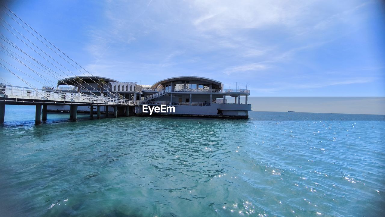 water, sea, sky, ocean, architecture, built structure, nature, transportation, blue, travel destinations, cloud, travel, reflection, scenics - nature, nautical vessel, vacation, building exterior, no people, beauty in nature, day, outdoors, tourism, wave, land, bridge, vehicle, horizon, holiday, tranquility, trip, mode of transportation, city, tranquil scene, ship, coast, horizon over water, bay