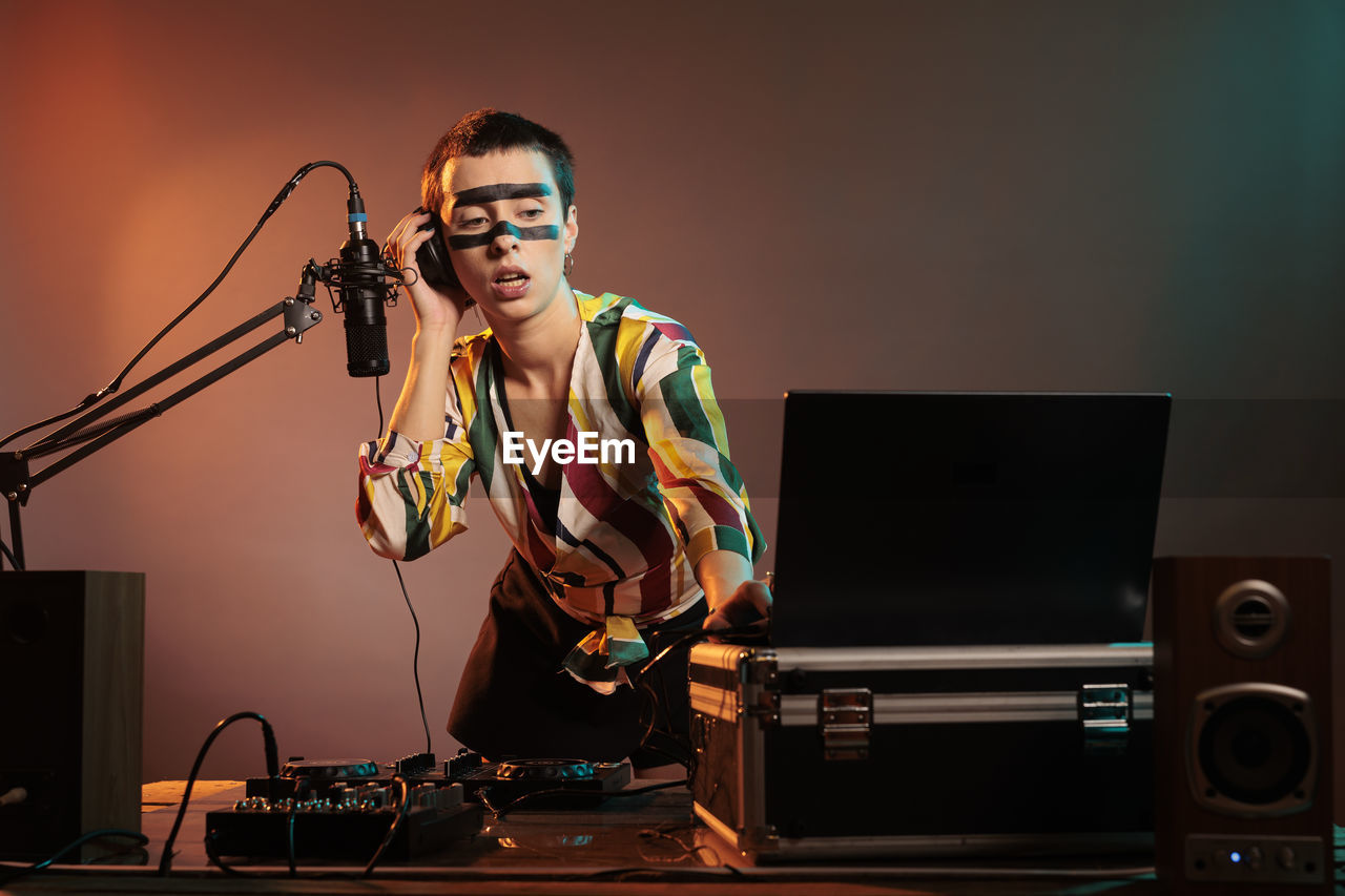 portrait of young man using mobile phone at music